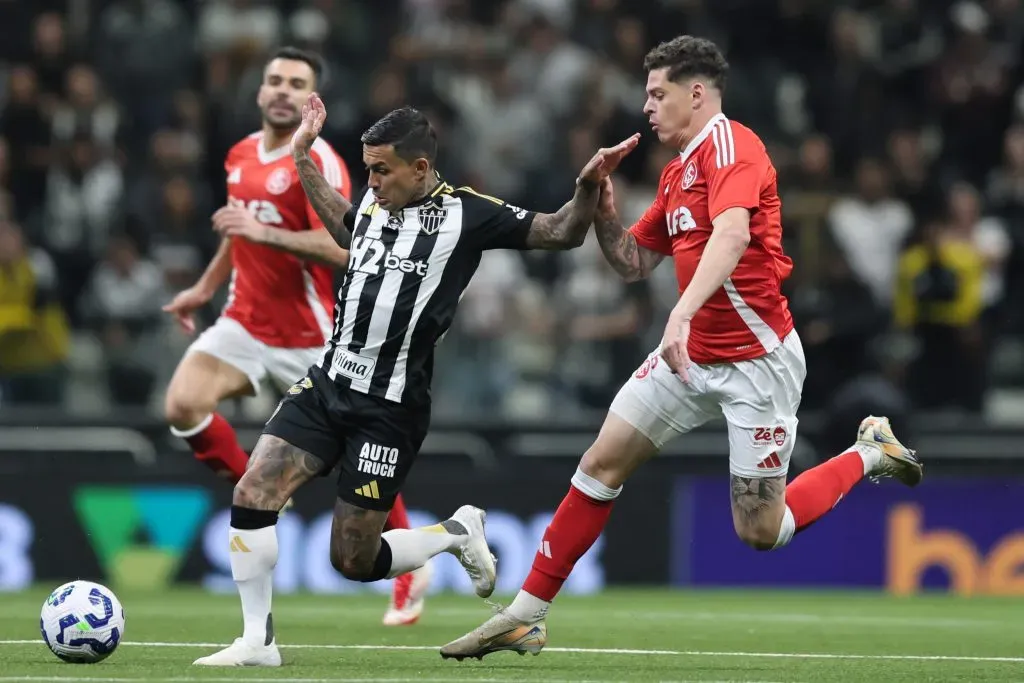 Dudu jogador do Atletico-MG disputa lance com Ronaldo jogador do Internacional durante partida no estadio Arena MRV pelo campeonato Brasileiro A 2025. Foto: Gilson Lobo/AGIF
