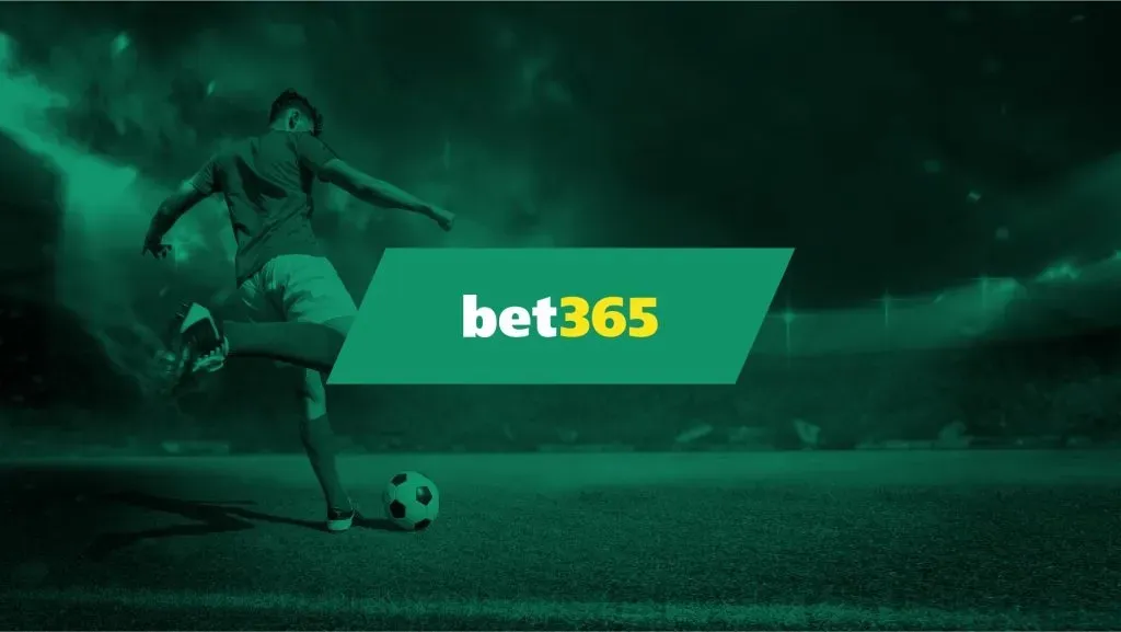 Imagem de divulgação da bet365 com o logo, em tons de branco e amarelo, contra fundo em tons sépia. No fundo, a imagem de jogador prestes a chutar uma bola em estádio.