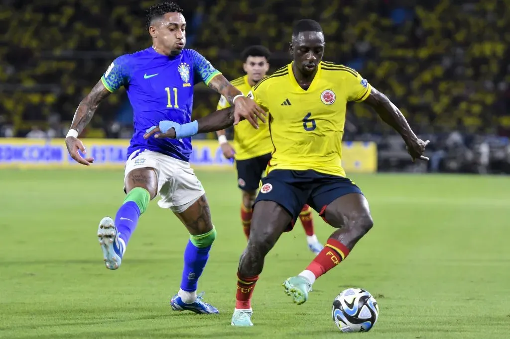 Déiver Machado disputa el balón con Raphinha, durante el partido entre Colombia y Brasil. / Getty Images.