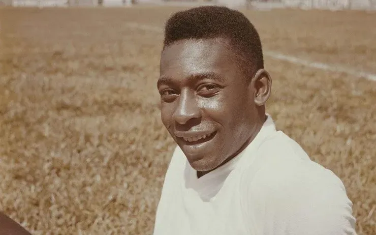 Pele (Edson Arantes do Nascimento) posed sitting on a football pitch circa 1960.