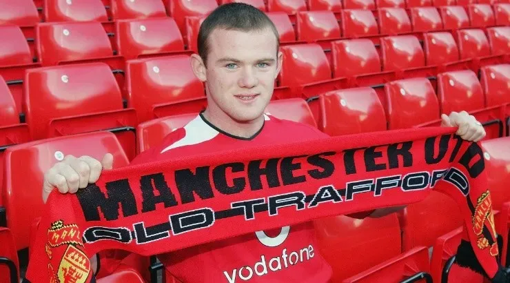 Wayne Rooney poses for photographs with a Manchester United scarf after signing. (Getty)