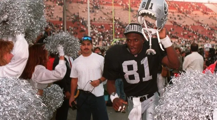 Tim Brown of the Los Angeles Raiders with helmet aloft leaves the field in 1994. (Getty)