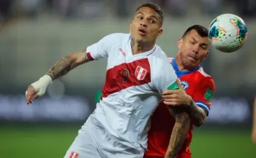 Paolo Guerrero during his last game with Peru (left) fighting for ball possession against Gary Medel of Chile on October 7 2021