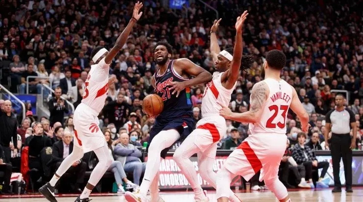 Joel Embiid #21 of the Philadelphia 76ers drives to the net against Chris Boucher #25 and Precious Achiuwa #5 of the Toronto Raptors(Photo by Cole Burston/Getty Images)