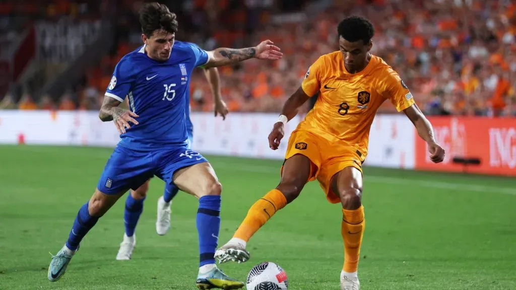 Cody Gakpo of Netherlands controls the ball whilst under pressure from Lazaros Rota of Greece-Dean Mouhtaropoulos/Getty Images