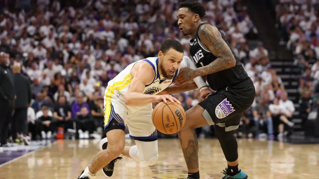 Stephen Curry #30 of the Golden State Warriors dribbles against Malik Monk #0 of the Sacramento Kings