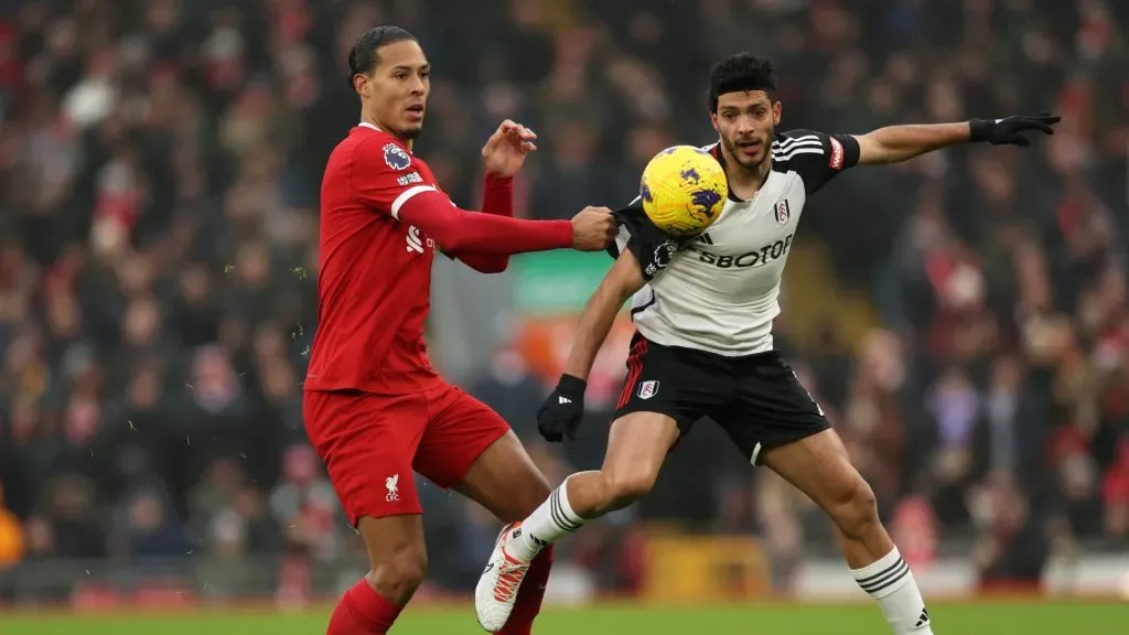 Virgil van Dijk of Liverpool battles for possession with Raul Jimenez of Fulham during the Premier League match between Liverpool FC and Fulham FC at Anfield on December 03, 2023 in Liverpool, England.