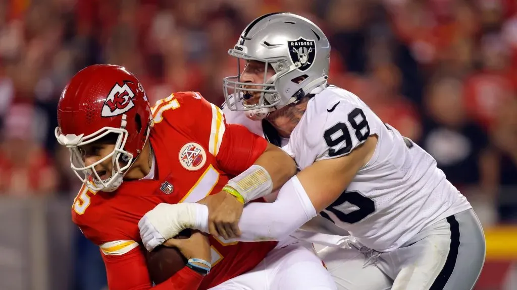 Quarterback Patrick Mahomes #15 of the Kansas City Chiefs is sacked by Maxx Crosby #98 of the Las Vegas Raiders during the 1st quarter of the game at Arrowhead Stadium on October 10, 2022 in Kansas City, Missouri.