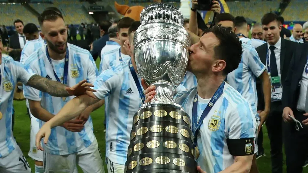 Lionel Messi of Argentina kisses the trophy as he celebrates with teammates after winning the final of Copa America Brazil 2021 between Brazil and Argentina at Maracana Stadium on July 10, 2021 in Rio de Janeiro, Brazil.