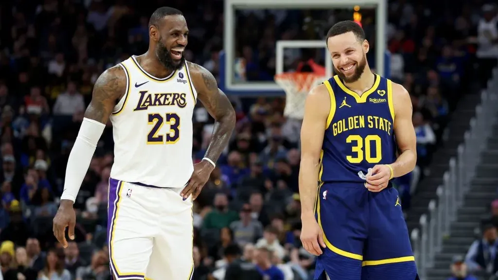LeBron James and Stephen Curry laughing during a game.