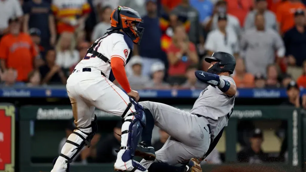 Aaron Judge #99 of the New York Yankees scores a run against catcher Yanier Diaz #21 of the Houston Astros on a sacrifice fly off the bat of Alex Verdugo in the seventh inning against at Minute Maid Park on March 28, 2024 in Houston, Texas.