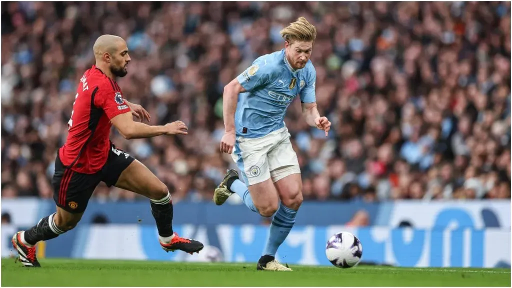 Kevin De Bruyne of Manchester City breaks with the ball tracked by Sofyan Amrabat of Manchester United ā IMAGO / News Images