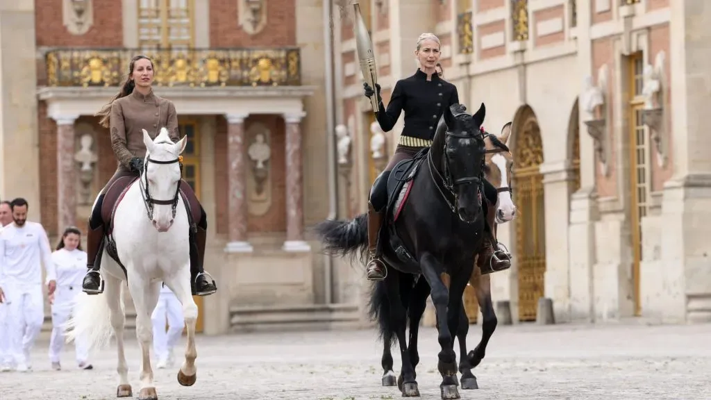A horsewoman carries the flame during the Paris Olympics torch relay on July 23, 2024 in Versailles, France. Paris will host the Summer Olympics from July 26 to August 11, 2024. (Photo by Lyvans Boolaky/Getty Images)
