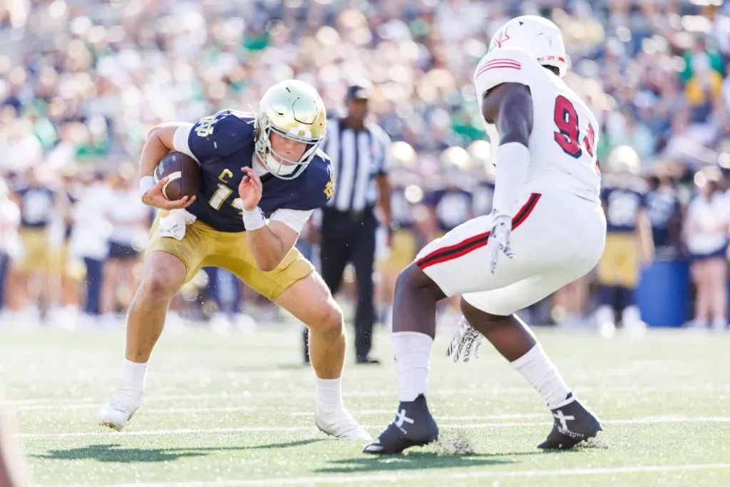 September 21, 2024: Notre Dame quarterback Riley Leonard 13 runs with the ball as Miami OH defensive lineman Josh Lukusa 94 pursues during NCAA, College League, USA football game action between the Miami OH RedHawks and the Notre Dame Fighting Irish at Notre Dame Stadium in South Bend, Indiana. Copyright: John Mersits