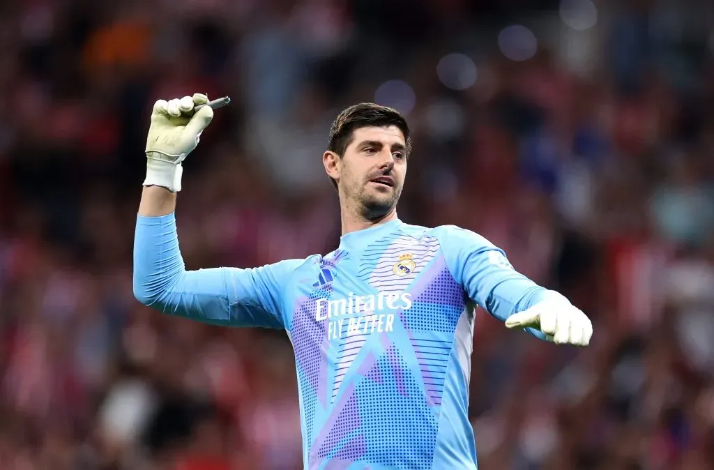 Thibaut Courtois of Real Madrid removes a cigarette lighter from the pitch during the LaLiga match between Atletico de Madrid and Real Madrid CF. Florencia Tan Jun/Getty Images