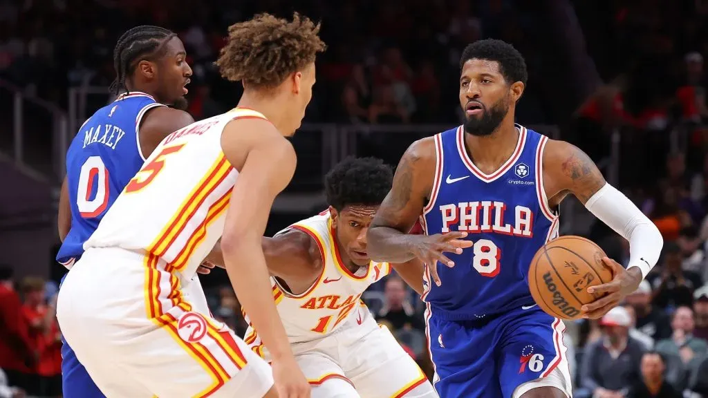 Paul George #8 of the Philadelphia 76ers drives against De’Andre Hunter #12 and Dyson Daniels #5 of the Atlanta Hawks during the first quarter at State Farm Arena on October 14, 2024 in Atlanta, Georgia. (Photo by Kevin C. Cox/Getty Images)
