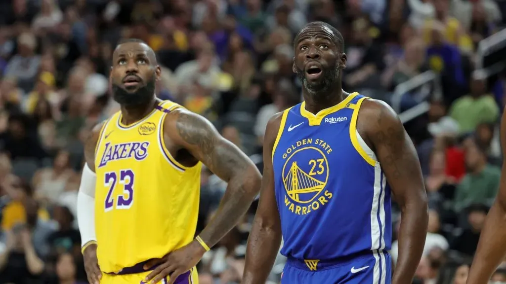 LeBron James #23 of the Los Angeles Lakers and Draymond Green #23 of the Golden State Warriors watch as a Warriors player shoots a free throw in the first quarter of their preseason game at T-Mobile Arena at T-Mobile Arena on October 15, 2024 in Las Vegas, Nevada. The Warriors defeated the Lakers 111-97. (Photo by Ethan Miller/Getty Images)