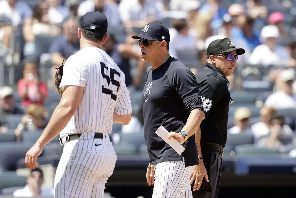 Manager Aaron Boone #17 of the New York Yankees gets in between Carlos Rodon #55