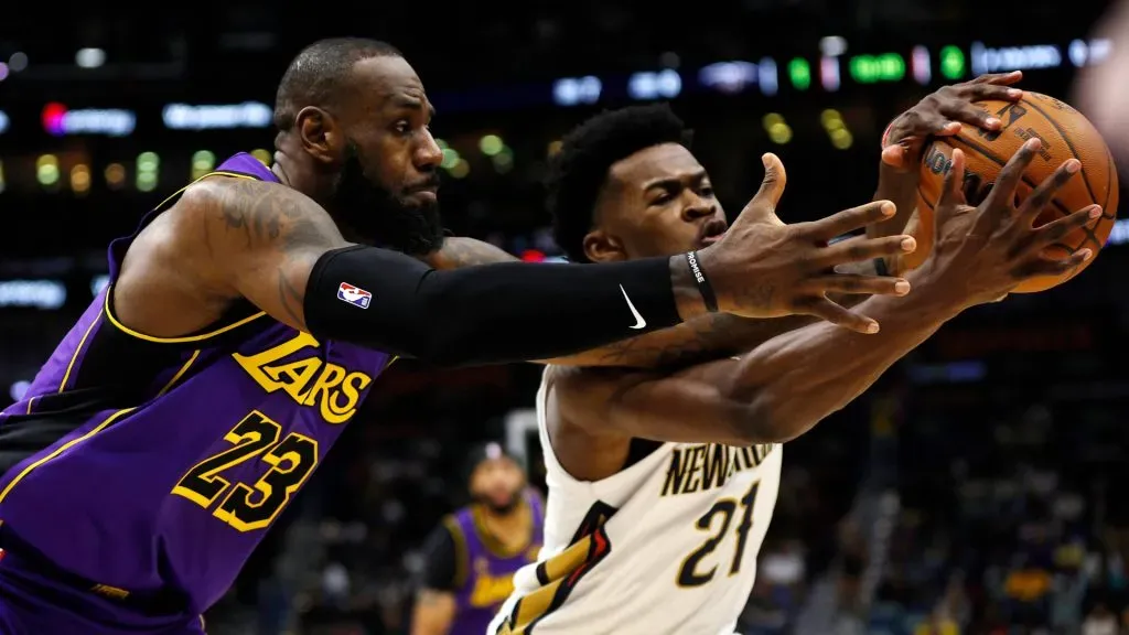 LeBron James #23 of the Los Angeles Lakers scrambles for a loose ball with Yves Missi #21 of the New Orleans Pelicans during the first quarter of an NBA game at Smoothie King Center. (Sean Gardner/Getty Images)