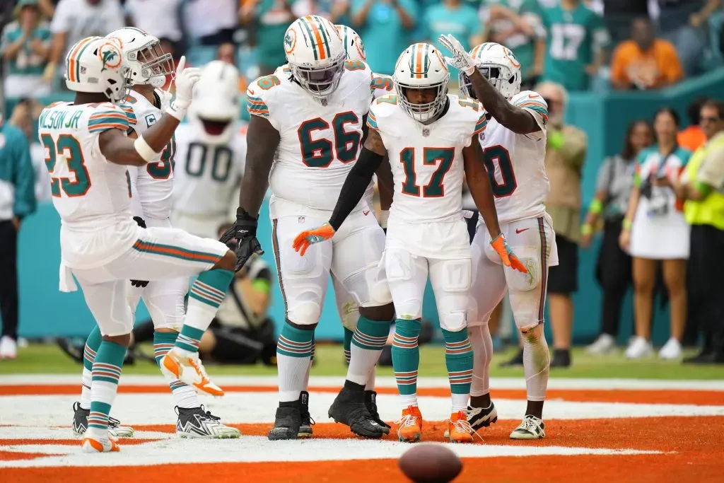 MIAMI GARDENS, FLORIDA – OCTOBER 29: Lester Cotton #66 of the Miami Dolphins and Tyreek Hill #10 of the Miami Dolphins celebrate with Jaylen Waddle #17 of the Miami Dolphins after Waddle’s receiving touchdown during the fourth quarter against the New England Patriots at Hard Rock Stadium on October 29, 2023 in Miami Gardens, Florida. (Photo by Rich Storry/Getty Images)