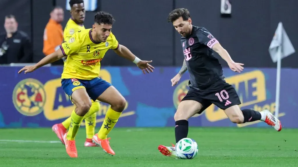 Lionel Messi #10 of Inter Miami CF kicks the ball under pressure from Sebastian Caceres #4 of America in the first half of their preseason friendly match. (Ethan Miller/Getty Images)