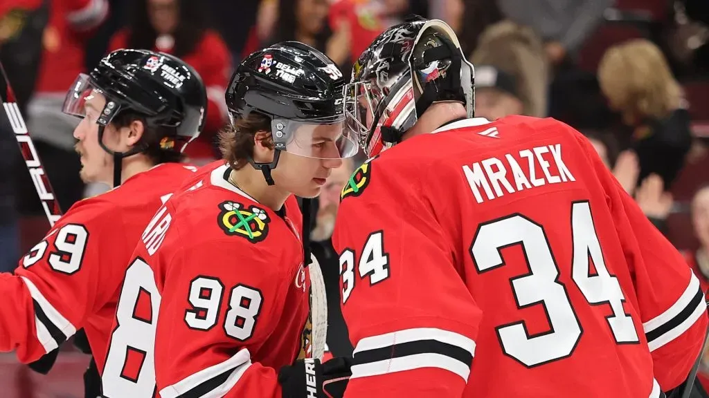 Connor Bedard #98 and Petr Mrazek #34 of the Chicago Blackhawks celebrate after defeating the Nashville Predators at the United Center on February 07, 2025 in Chicago, Illinois.
