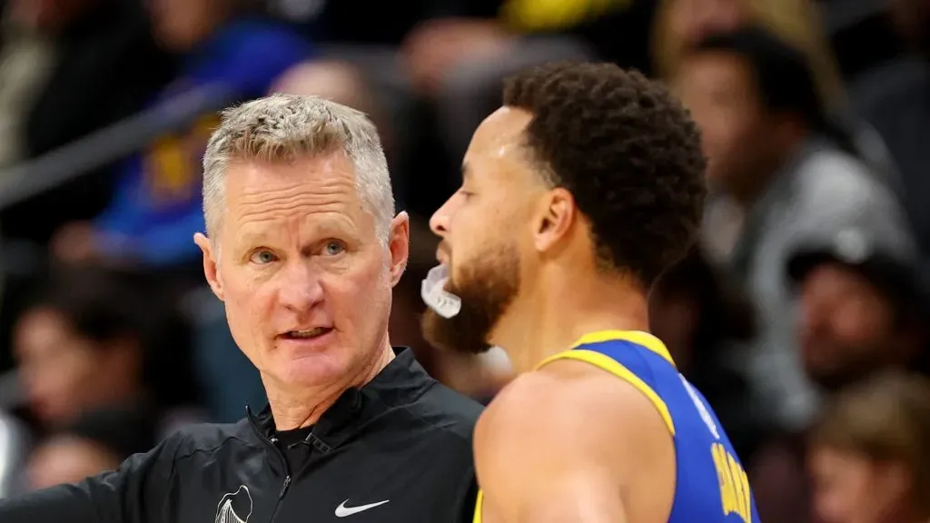 Head Coach Steve Kerr of the Golden State Warriors speaks with Stephen Curry #30 against the Denver Nuggets