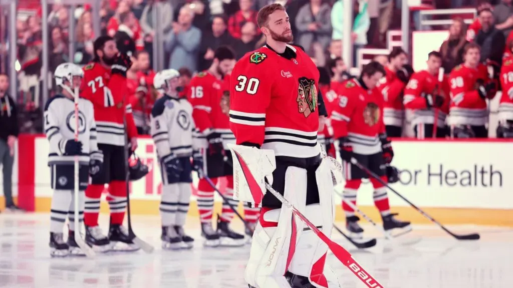Spencer Knight #30 of the Chicago Blackhawks looks on during the playing of the national anthem. (Photo by Michael Reaves/Getty Images)