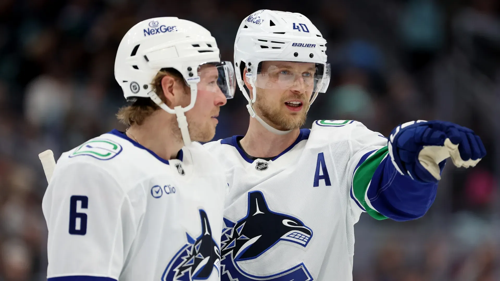 Brock Boeser #6 and Elias Pettersson #40 of the Vancouver Canucks talk during an NHL game. Steph Chambers/Getty Images