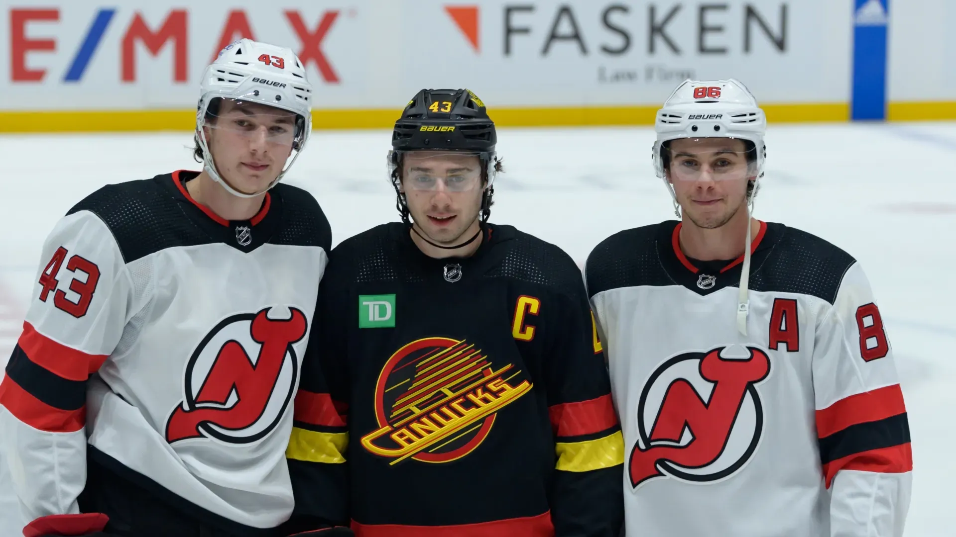 Luke Hughes (left), Quinn Hughes (middle), and Jack Hughes (right) before a game