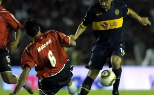Riquelme pelea la pelota con Eduardo Tuzzio, en una de las últimas visitas del enganche al Libertadores de América.
