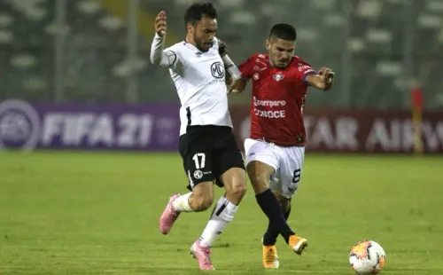 Carlos Melgar, con la camiseta de Jorge Wilstermann, siendo marcado por Gabriel Suazo (Foto: Getty Images).