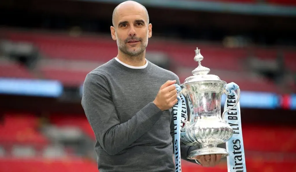Pep Guardiola junto a uno de sus títulos de FA Cup: IMAGO