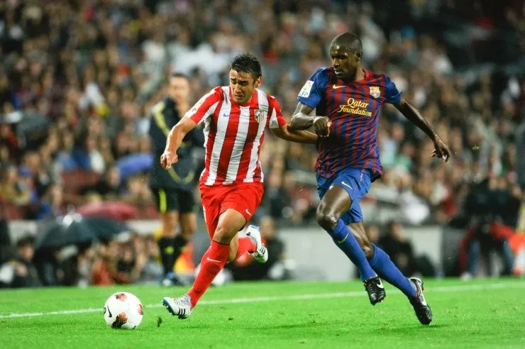 Dani Alves enfrentando a Eric Abidal. Créditos: Getty Images