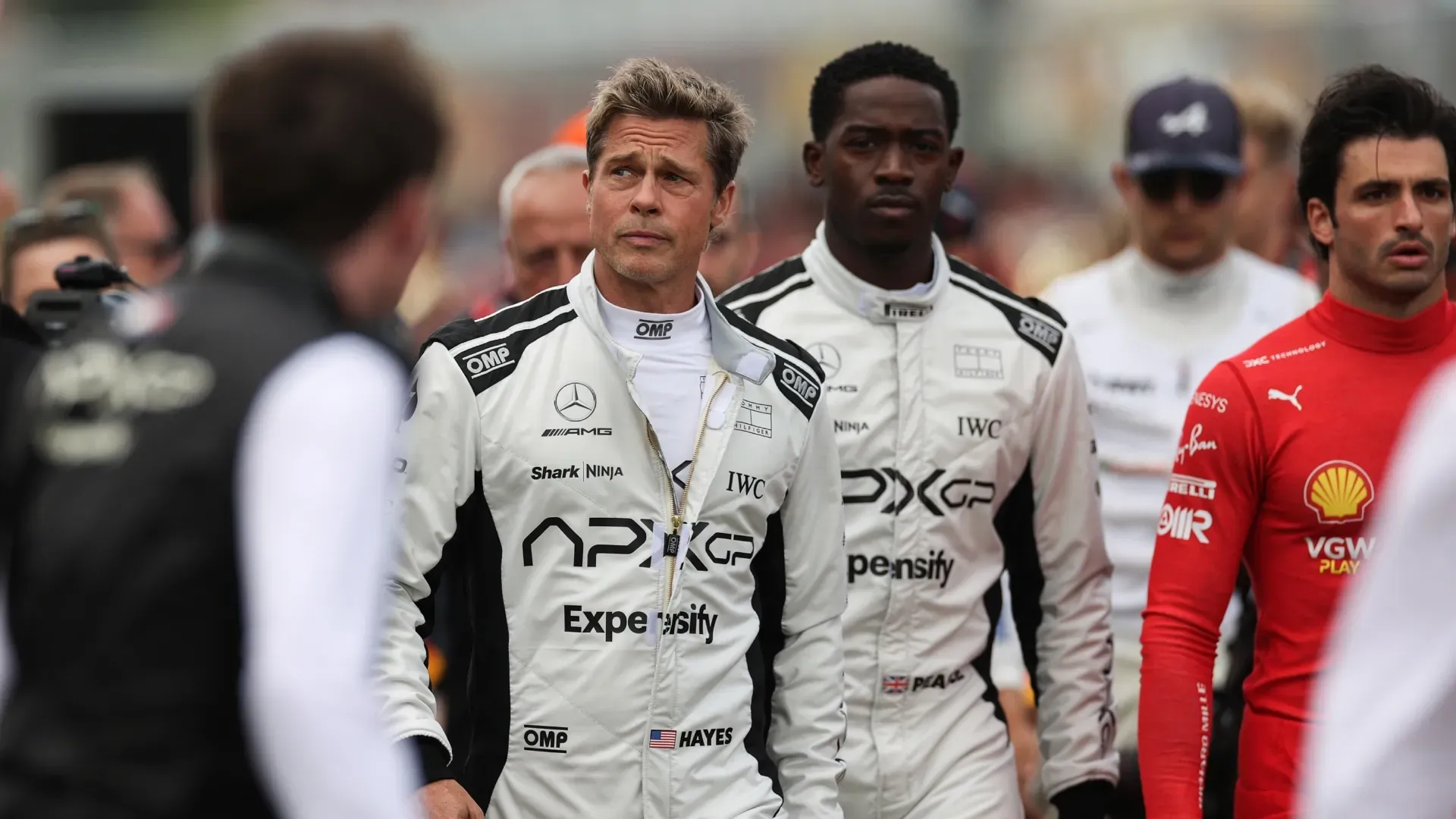 rad Pitt, star of the upcoming Formula One based movie, Apex, and Damson Idris, co-star of the upcoming Formula One based movie, Apex, walk on the grid in front of Carlos Sainz of Spain driving (55) the Ferrari SF-23 on track during the F1 Grand Prix of Great Britain at Silverstone Circuit on July 09, 2023 in Northampton, England. (Photo by Ryan Pierse/Getty Images)