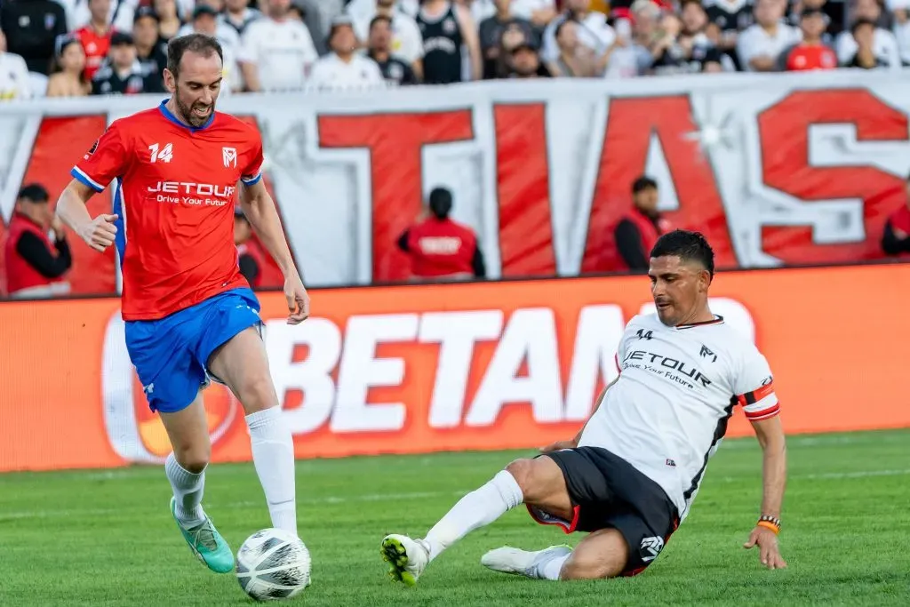 Miguel Riffo disputa un balón con Diego Godín en la despedida de Matías Fernández. | Imagen: Guille Salazar/DaleAlbo.