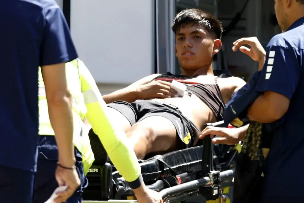 Dixon Pereira se retira en ambulancia tras el choque con Maximiliano Falcón. | Imagen: Photosport