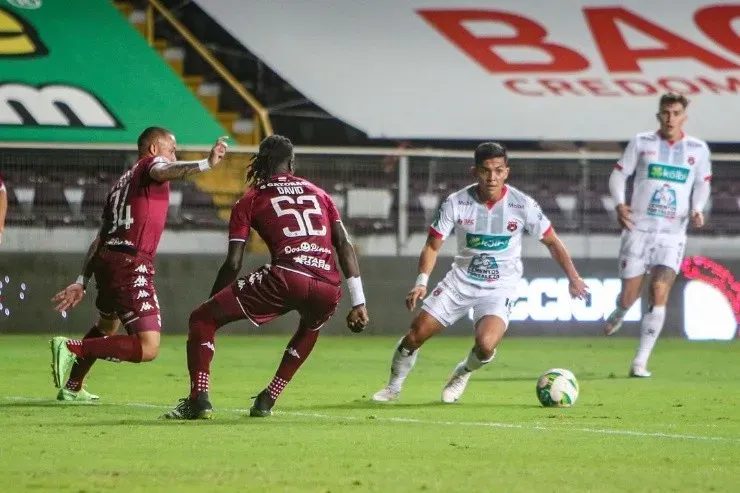 Aubrey David intenta marcar a Alonso Martínez de Alajuelense