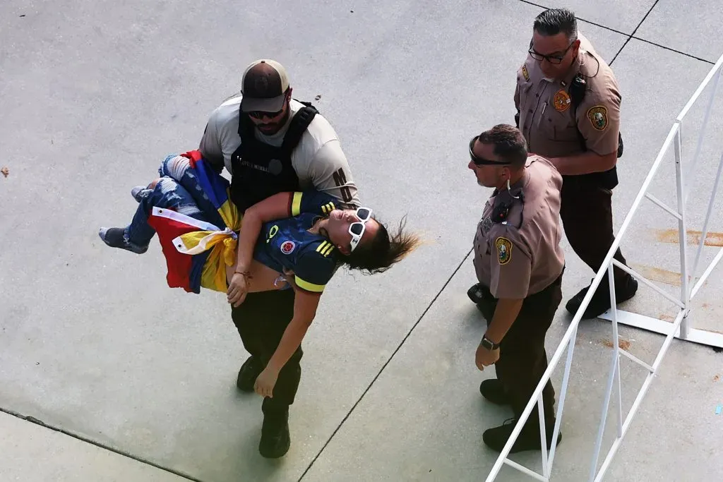 MIAMI GARDENS, FLORIDA – JULY 14: A police officer carries an unconscious fan the CONMEBOL Copa America 2024 Final match between Argentina and Colombia at Hard Rock Stadium on July 14, 2024 in Miami Gardens, Florida. (Photo by Megan Briggs/Getty Images)