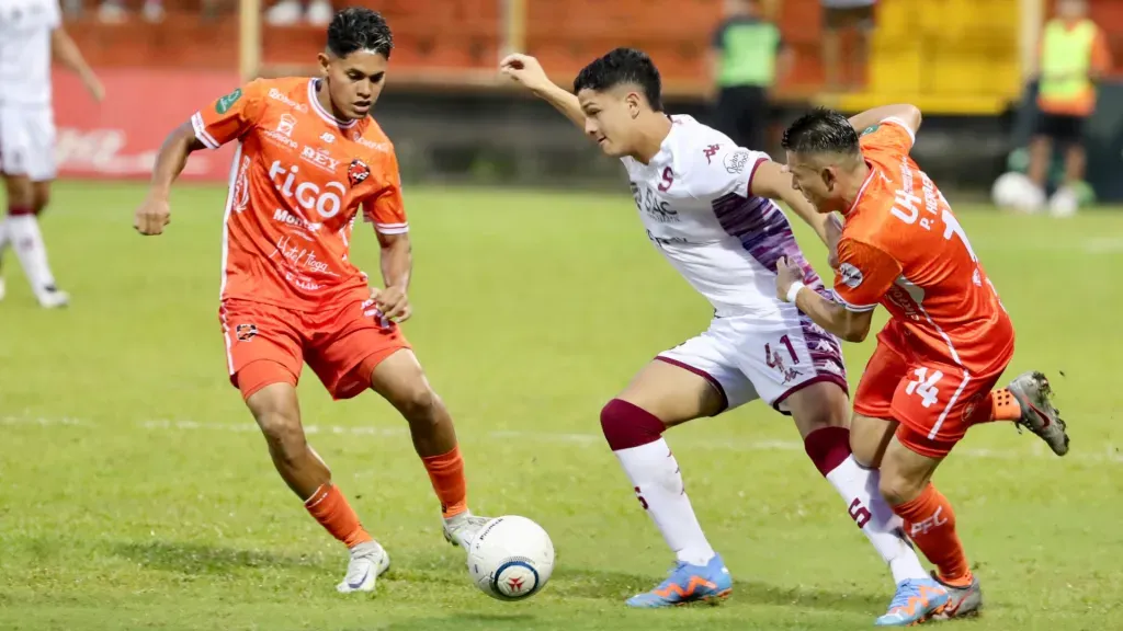 Warren Madrigal protege la bola de la marca de Pablo Herrera. (Foto: Alonso Tenorio / La Teja)