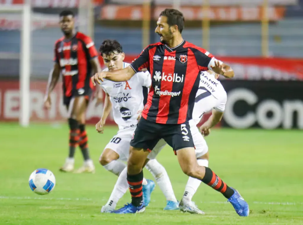 Leo Menjívar pelea por arrebatarle la bola a Celso Borges. (Foto: Concacaf.com)