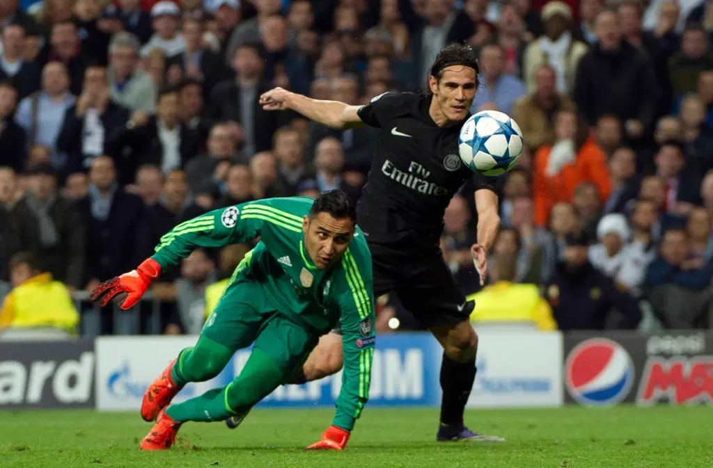 Keylor Navas y Edinson Cavani pelean por la bola en un duelo correspondiente a los octavos de final de la Champions League 2018. Real Madrid le ganó 5-2 en el global a PSG. (Foto: AFP)