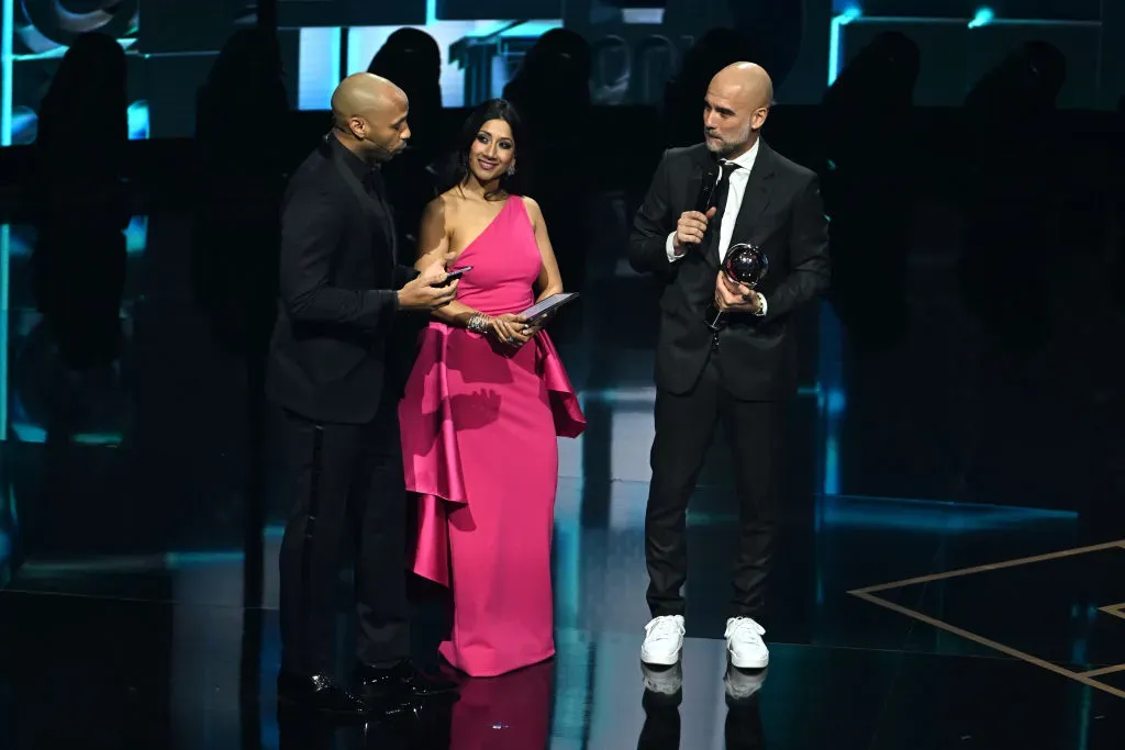 LONDON, ENGLAND – JANUARY 15: Presenters, Thierry Henry and Reshmin Chowdhury, speak with FIFA Men’s Coach of the Year, Pep Guardiola, during the The Best FIFA Football Awards 2023 at The Apollo Theatre on January 15, 2024 in London, England. (Photo by Kate Green/Getty Images)