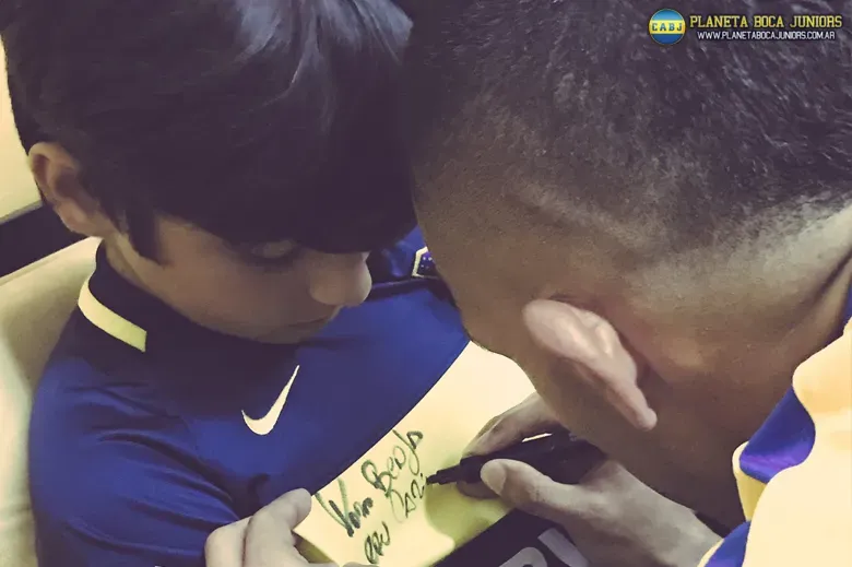 El nieto de Maradona recibiendo la firma de Carlos Tevez.