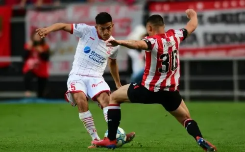 Juan Fuentes (30) traba ante César Ibáñez en un partido entre Estudiantes y Huracán. (Foto: Getty Images)