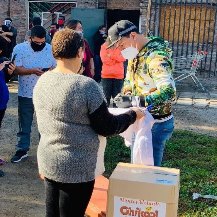 Esteban Paredes compartiendo con las familias de Cerro Navia, a quienes les entregó cajas de mercaderías, se sacó fotografías y dio autógrafos. (FOTO: @e.paredes7/)
