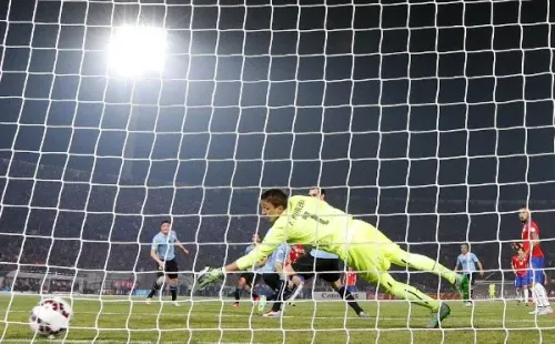 Fernando Muslera se estiró lo que más pudo, pero no logró alcanzar el feroz remate de Mauricio Isla en Copa América. Foto: Getty Images