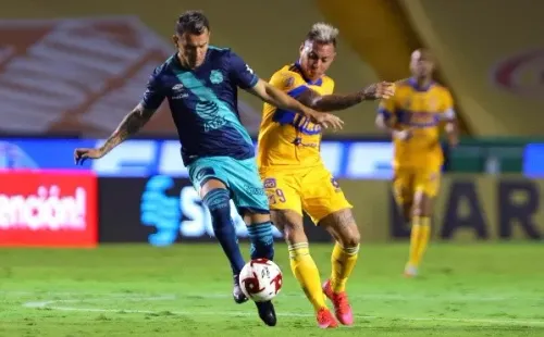 Eduardo Vargas disputa el balón con Maximiliano Perg en el Tigres vs. Puebla.