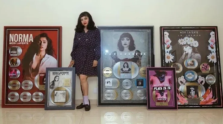 Mon Laferte junto a sus discos de Oro, Platino y Diamante.