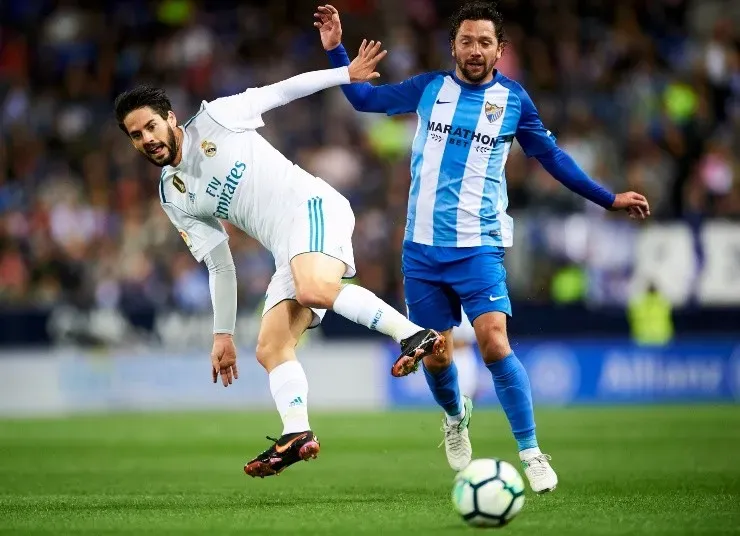 Manuel Iturra durante su paso por el Málaga, y a su lado Isco, en un choque ante Real Madrid. | Foto: Getty Images.